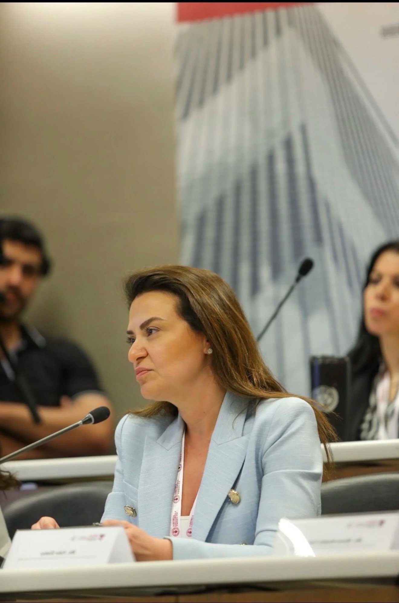 Hala Achkar Slaiby seated at a table with a microphone during a leadership discussion.